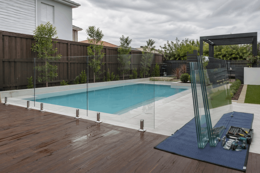 Glass pool fencing panels removed and placed safely during backyard pool renovation